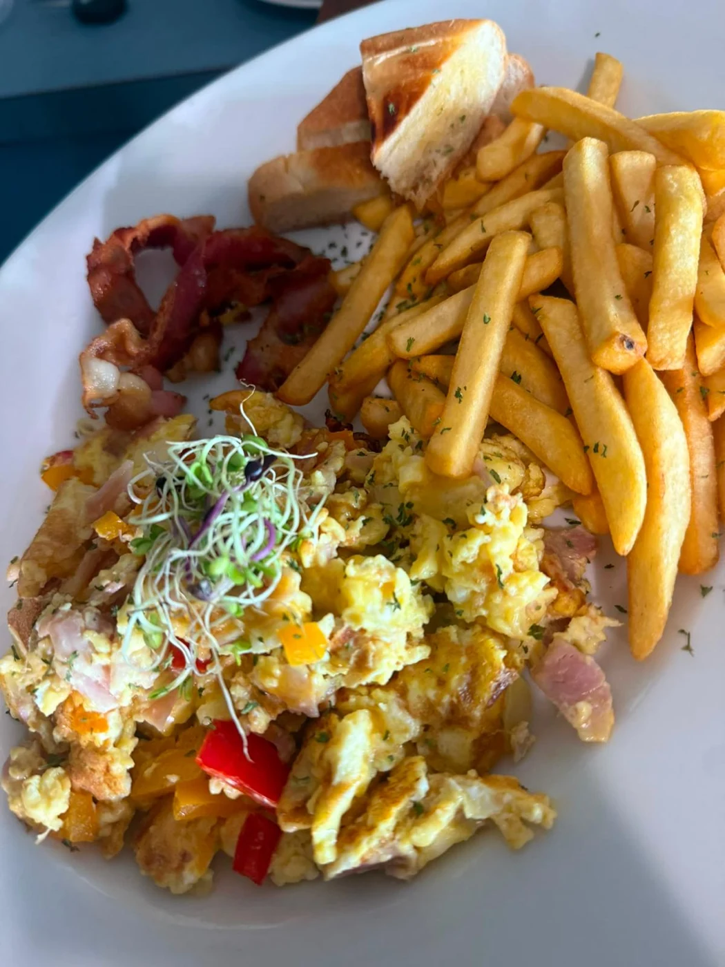 Desayuno con huevos, tostadas y papitas fritas