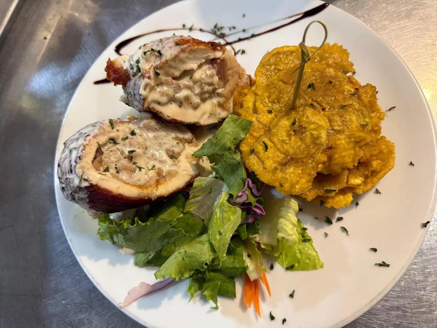 Pechuga rellena cortada en dos con mofongo y ensalada